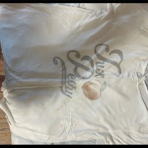Loose fitting white shirt with words “just peachy”